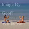 GW16390-50 = Scene on Es Trenc beach ( Platja de Trenc) in SE Mallorca ( two well tanned girls doing meditation / yoga exercises by waters edge ), Baleares, Spain.