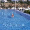 GW30125-60 = Scene at Cala D'Or Yacht Club - swimmer in pool overlooking Marina of Cala D'Or, Cala D'Or, Ajuntamiento de Santanyi, South East Mallorca, Balearic Islands, Spain. 11th September 2007. Model Release.