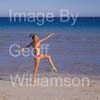 GW31755-60 = Young lady undertaking Tai Chi and fitness exercises on a beach in Mallorca, Spain.