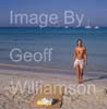 GW35125-60 = Young topless lady enjoying sun, sea and sand at Es Trenc beach ( with boats at anchor behind ) in SE Mallorca / Majorca, Balearic Islands, Spain.  17th August 2009. Model Release.